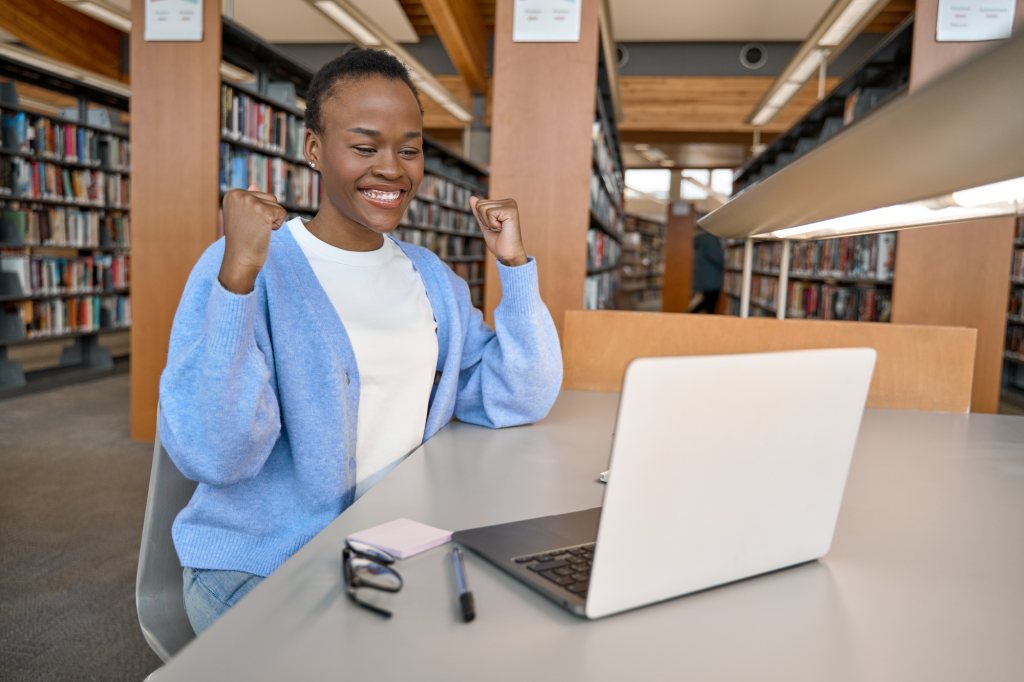 SACC Career Center student celebrating success while completing online coursework in the library